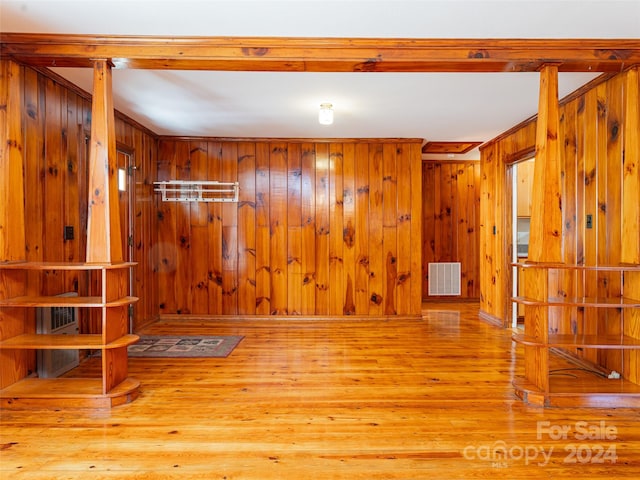 spare room with wood walls and light hardwood / wood-style floors