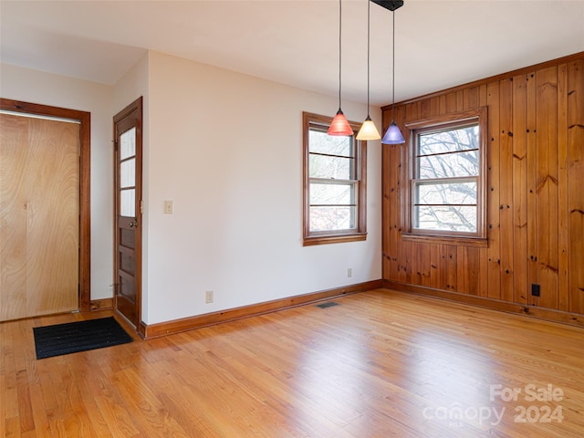 interior space with wood walls and light hardwood / wood-style flooring