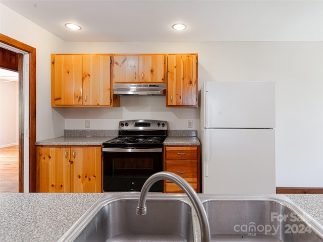 kitchen with stainless steel range with electric cooktop, wood-type flooring, sink, and white fridge