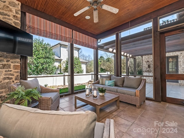 sunroom featuring ceiling fan and wooden ceiling