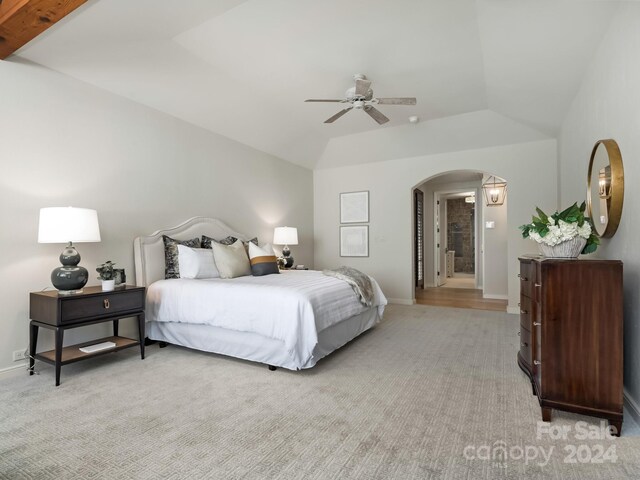 carpeted bedroom with ceiling fan, lofted ceiling, and ensuite bathroom