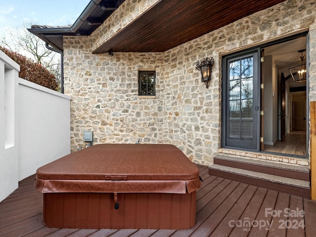 wooden terrace featuring a covered hot tub