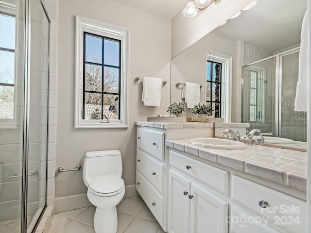 bathroom featuring a shower with door, tile flooring, large vanity, and toilet