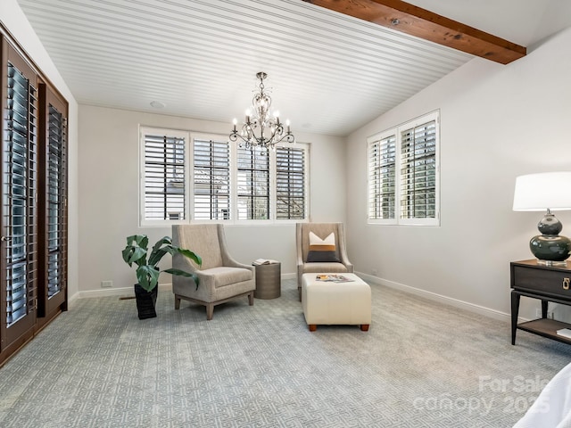 living area with beam ceiling, light colored carpet, a notable chandelier, and baseboards