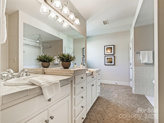 full bathroom featuring double vanity, baseboards, and visible vents