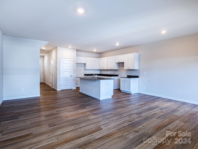 kitchen featuring dark hardwood / wood-style floors, sink, a center island with sink, and white cabinets