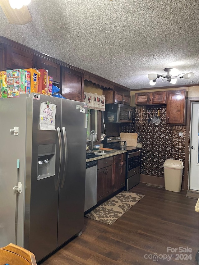 kitchen featuring ceiling fan, dark wood-type flooring, dark brown cabinets, appliances with stainless steel finishes, and sink