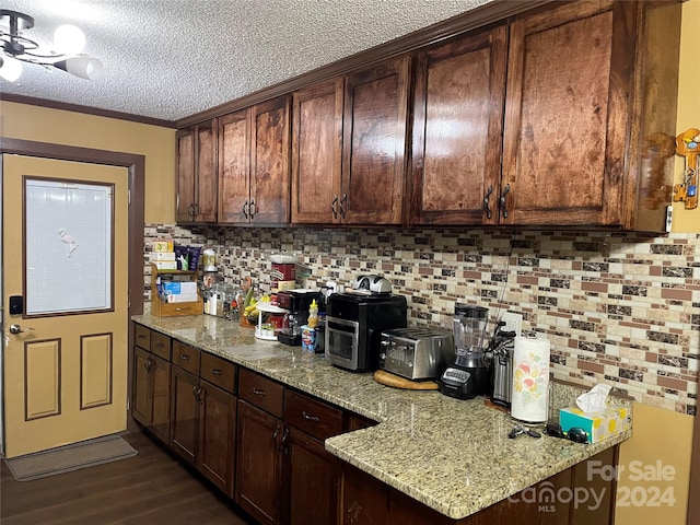 kitchen featuring dark brown cabinets and light stone counters