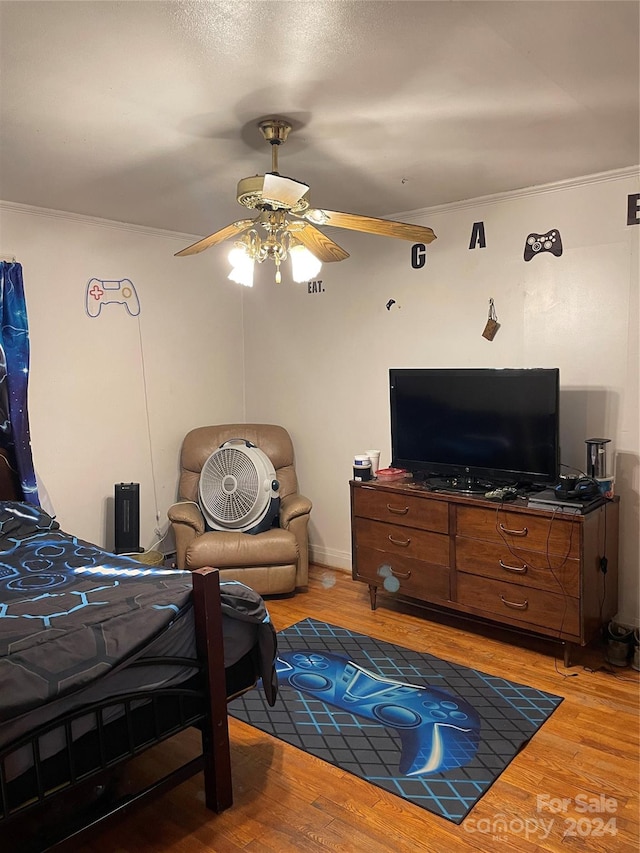 bedroom with crown molding, ceiling fan, and light hardwood / wood-style flooring