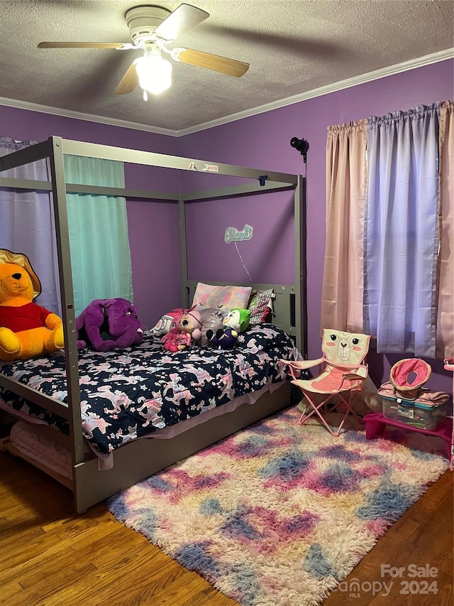 bedroom featuring ceiling fan, dark wood-type flooring, a textured ceiling, and crown molding