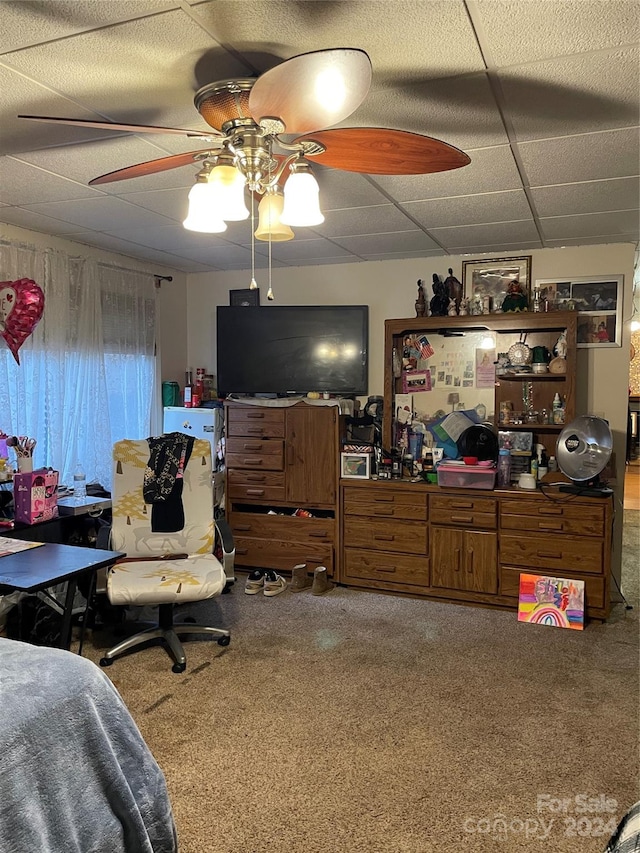 carpeted bedroom featuring ceiling fan and a drop ceiling