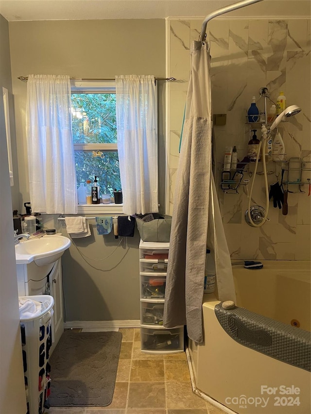 bathroom with tile floors, vanity, and shower / bath combo with shower curtain