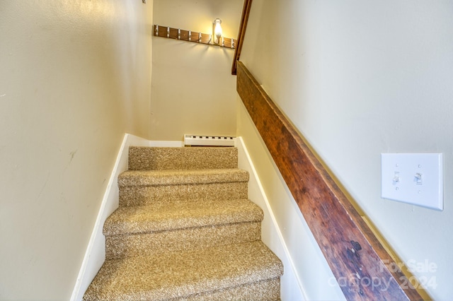 stairway featuring baseboard heating