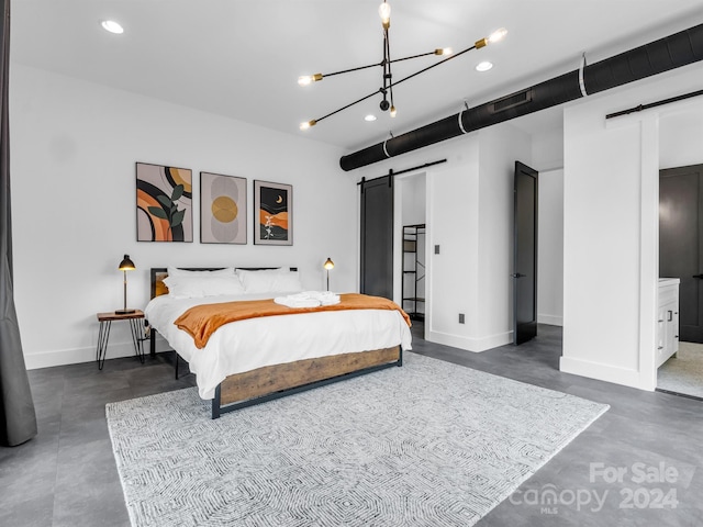 bedroom with a barn door, ensuite bath, and a chandelier