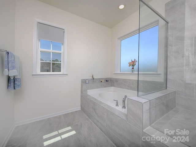 bathroom featuring tiled tub and tile patterned flooring