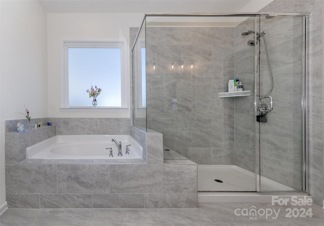 bathroom featuring shower with separate bathtub