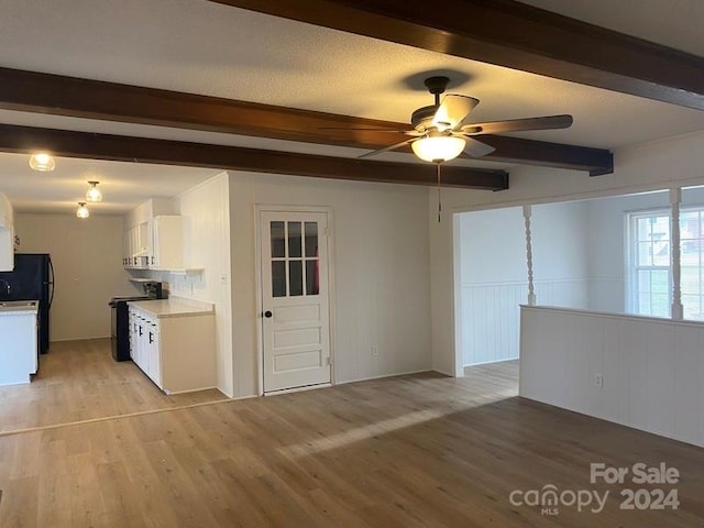 spare room with beam ceiling, ceiling fan, and light hardwood / wood-style flooring