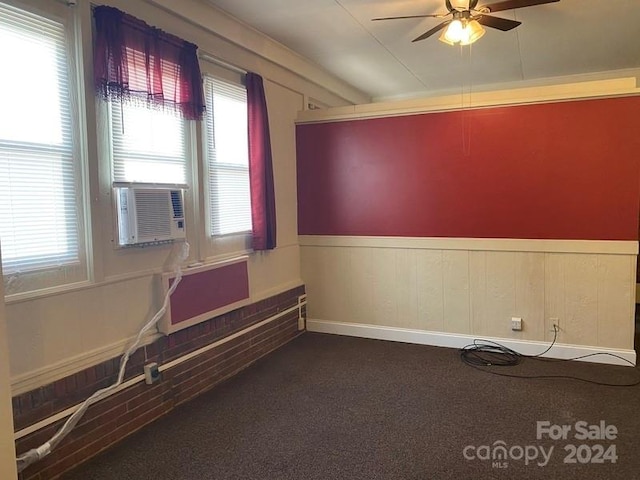 carpeted empty room with ceiling fan and a wealth of natural light