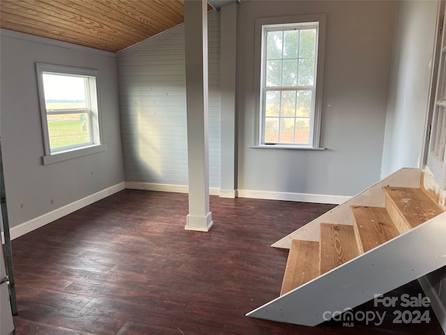 empty room with dark wood-type flooring, wooden ceiling, and vaulted ceiling