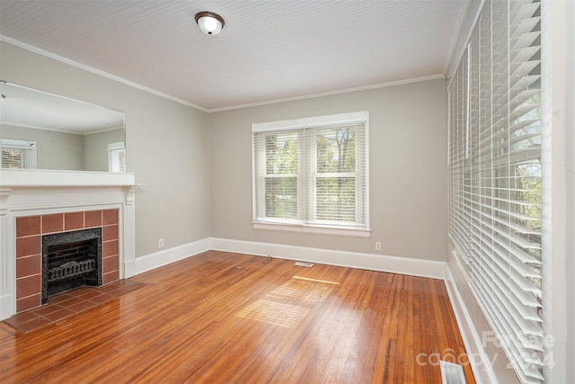 unfurnished living room featuring hardwood / wood-style flooring, crown molding, and a fireplace