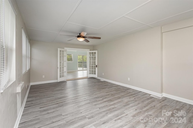 empty room featuring french doors, ceiling fan, and light wood-type flooring