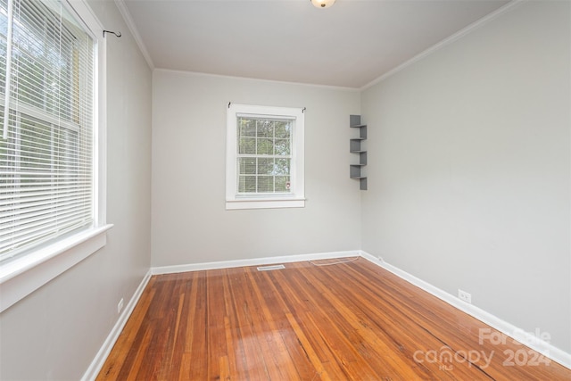 spare room featuring wood-type flooring and ornamental molding