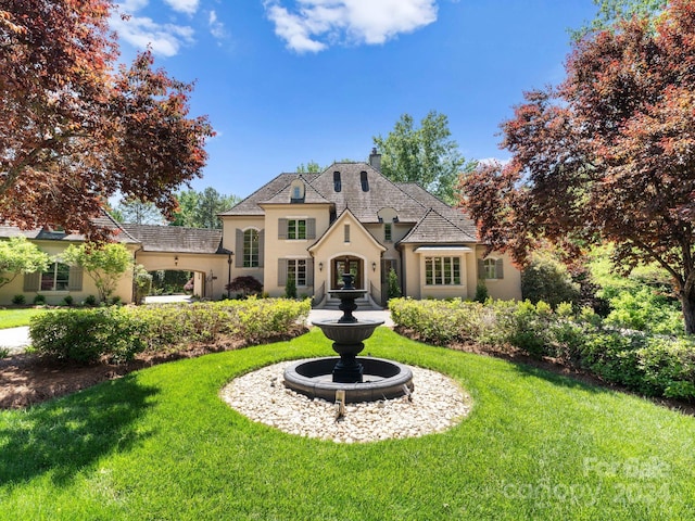 french provincial home featuring a front lawn