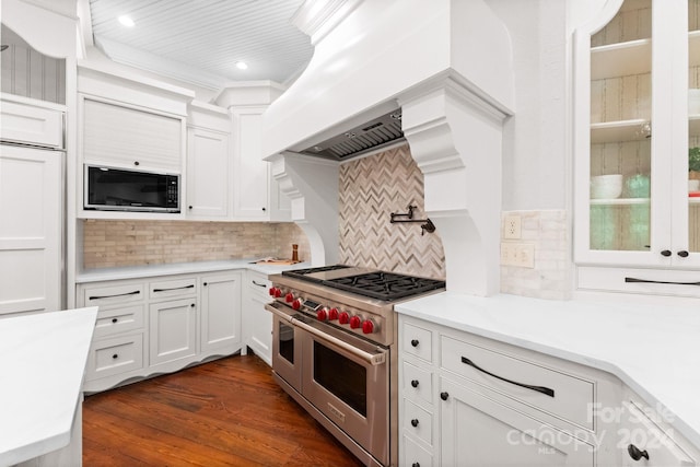 kitchen featuring backsplash, double oven range, built in microwave, and white cabinets