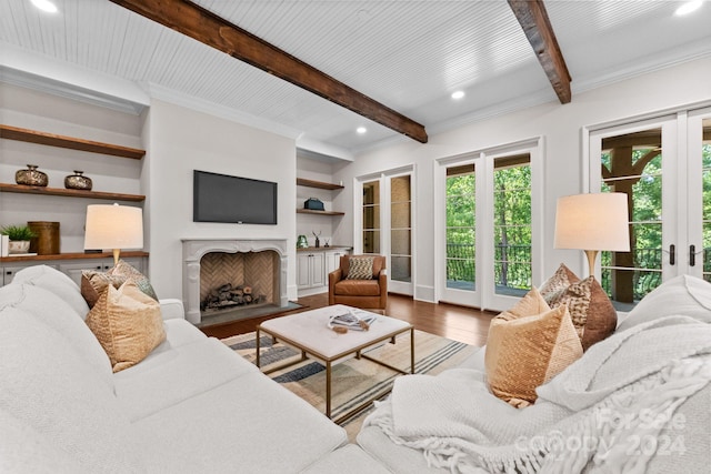 living room with a fireplace, french doors, hardwood / wood-style floors, ornamental molding, and beam ceiling