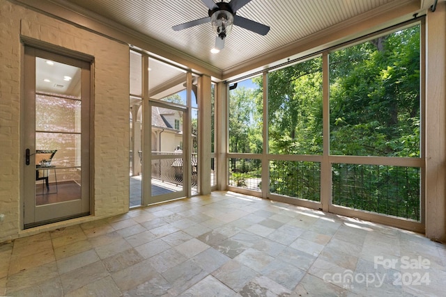 unfurnished sunroom with ceiling fan