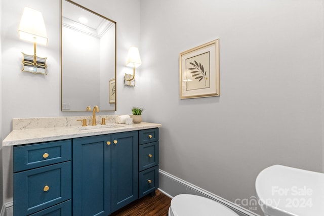 bathroom with wood-type flooring, toilet, and vanity