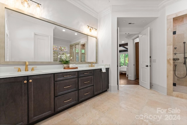 bathroom with crown molding, dual bowl vanity, tiled shower, and tile flooring