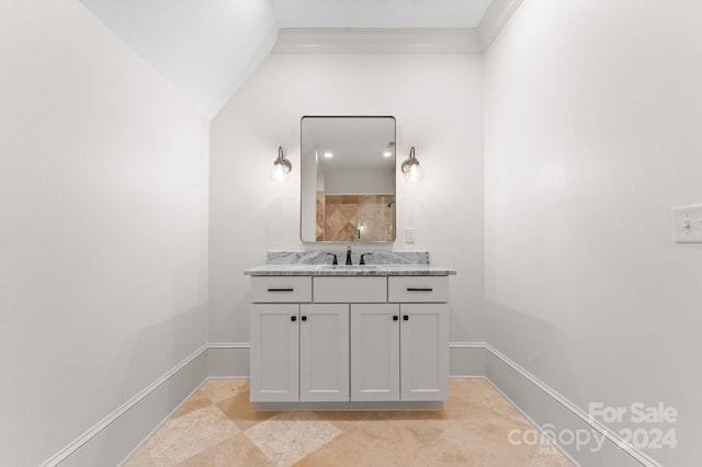 bathroom with ornamental molding, tile floors, vanity, and vaulted ceiling