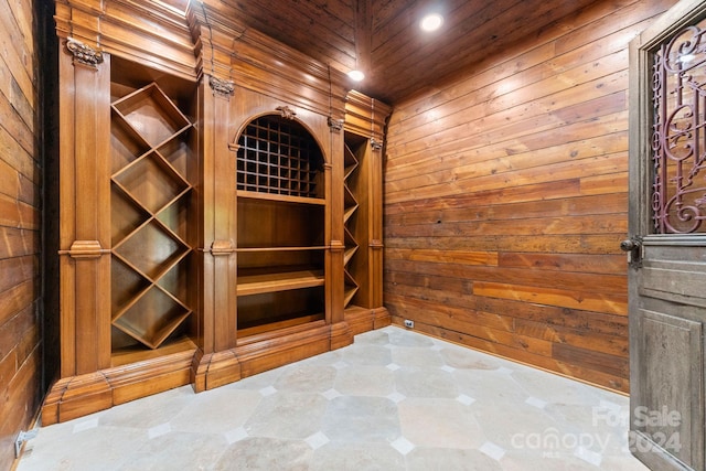 wine cellar featuring wooden ceiling and wood walls