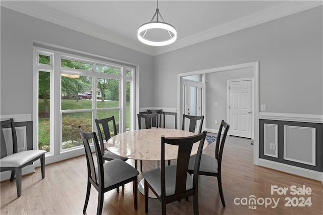 dining room with crown molding, plenty of natural light, and light wood-type flooring