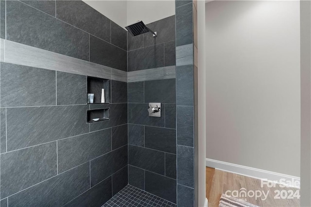 bathroom featuring wood-type flooring and tiled shower