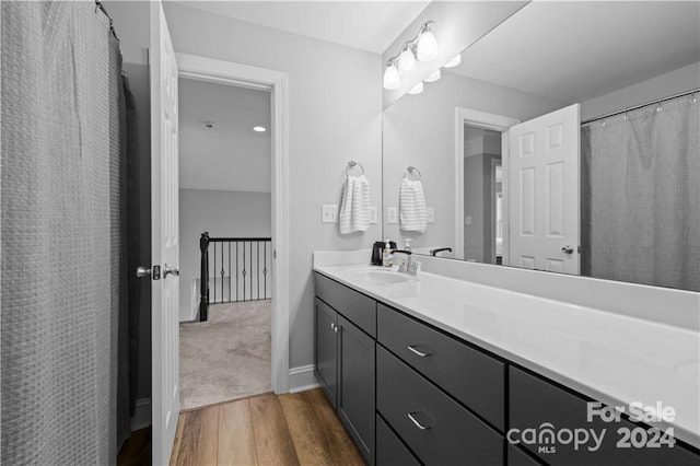 bathroom featuring wood-type flooring and large vanity