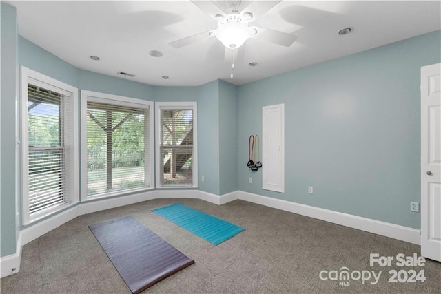 workout room with dark carpet and ceiling fan