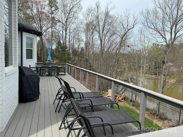 wooden deck with grilling area and a water view