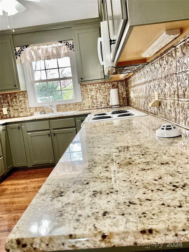 kitchen with ceiling fan, light stone countertops, light hardwood / wood-style flooring, and tasteful backsplash