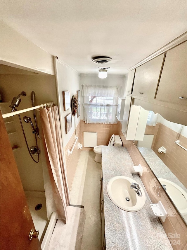 bathroom featuring toilet, walk in shower, vanity, and tile walls