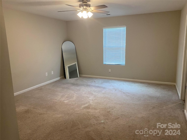 carpeted empty room featuring ceiling fan