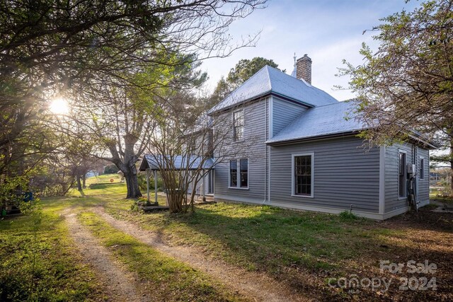 back of house featuring a lawn