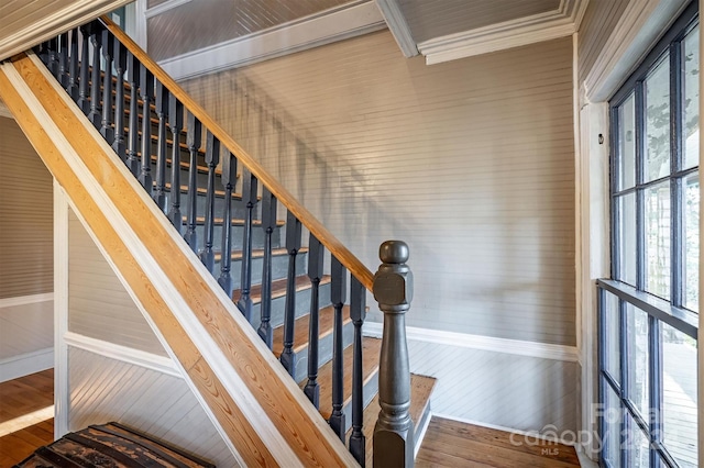 staircase with crown molding and dark wood-type flooring