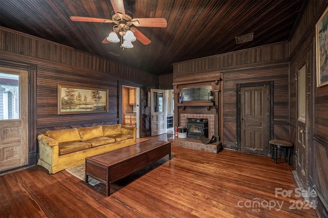 unfurnished living room with a fireplace, wooden ceiling, ceiling fan, wooden walls, and dark hardwood / wood-style flooring