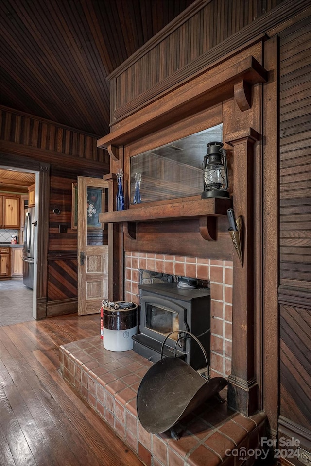 living room featuring wood walls, a wood stove, and dark hardwood / wood-style flooring