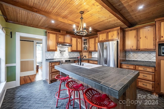 kitchen featuring backsplash, beam ceiling, stainless steel appliances, and dark wood-type flooring