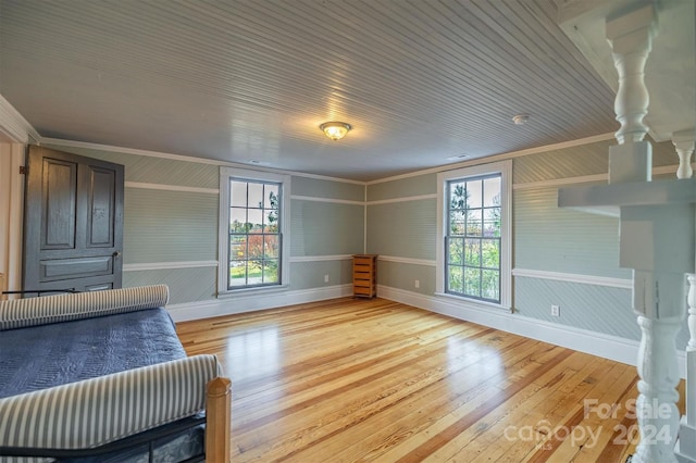 bedroom featuring multiple windows, light hardwood / wood-style flooring, and crown molding