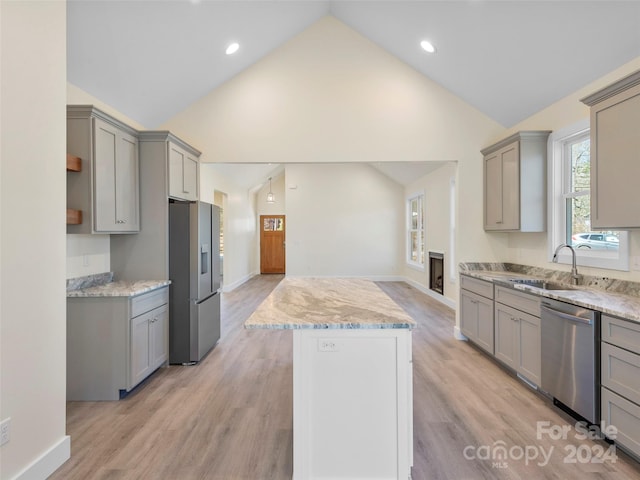 kitchen with light hardwood / wood-style floors, stainless steel appliances, sink, and gray cabinets