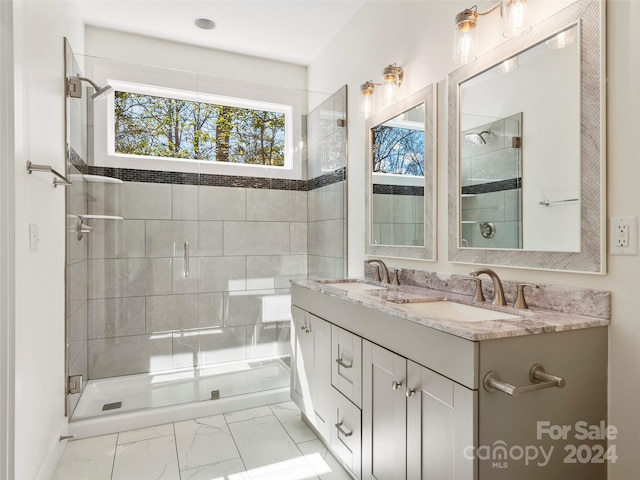 bathroom with a shower with door, dual sinks, tile floors, and oversized vanity